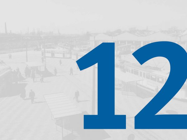 Vor einem blass-grauen historischen Foto vom Straßenbahndepot in Gröpelingen mit Fahrzeugen der BSAG steht in großer blauer Schrift die Zahl "12" des Adventskalenders der BSAG.