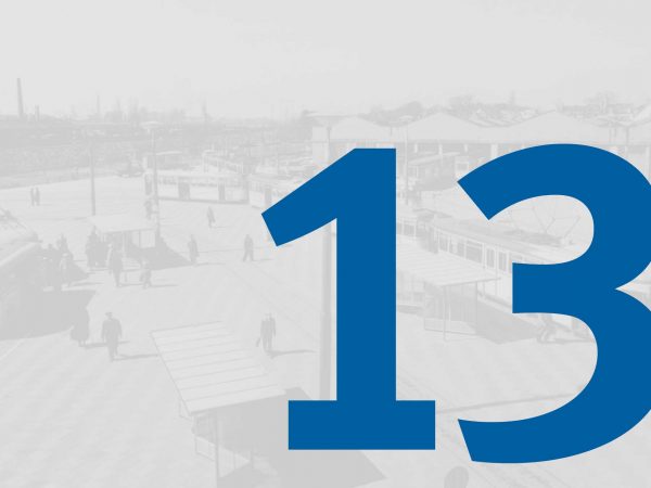 Vor einem blass-grauen historischen Foto vom Straßenbahndepot in Gröpelingen mit Fahrzeugen der BSAG steht in großer blauer Schrift die Zahl "13" des Adventskalenders der BSAG.