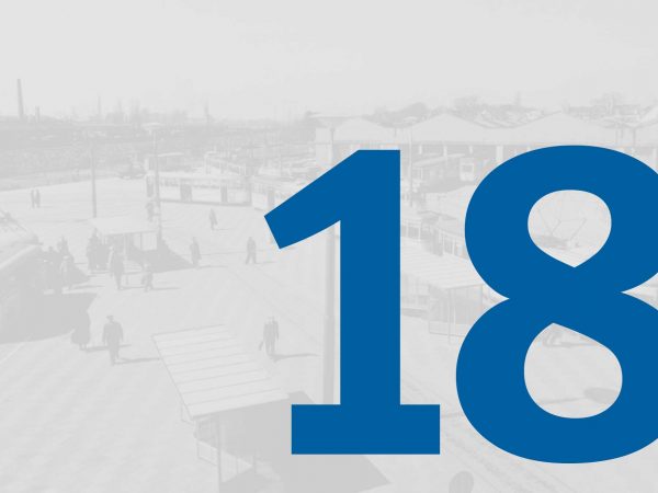 Vor einem blass-grauen historischen Foto vom Straßenbahndepot in Gröpelingen mit Fahrzeugen der BSAG steht in großer blauer Schrift die Zahl "18" des Adventskalenders der BSAG.
