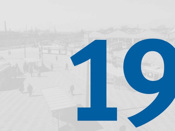 Vor einem blass-grauen historischen Foto vom Straßenbahndepot in Gröpelingen mit Fahrzeugen der BSAG steht in großer blauer Schrift die Zahl "19" des Adventskalenders der BSAG.