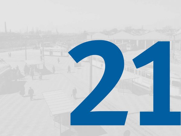 Vor einem blass-grauen historischen Foto vom Straßenbahndepot in Gröpelingen mit Fahrzeugen der BSAG steht in großer blauer Schrift die Zahl "21" des Adventskalenders der BSAG.